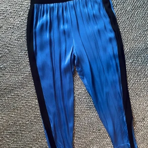 Marlene Birger byxor lounge / träning - Oanvända nya blå byxor från Marlene Birger, som träningsbyxor eller mjukisar. Funkar som finbyxor till fest eller avslappnat till gymmet. Nya med prislapp kvar.