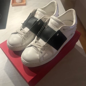Valentino Garavani sneakers  - Säljer ett par Valentino Garavani Calfskin Open Sneaker i storlek 39. Skorna är i mycket gott skick. Skokartong, dustbag och ett helt oanvänt par skosnören medföljer. Nypris idag är 7280 kr. Kvitto finns.