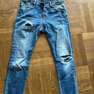 Blå jeans från Replay - Säljer dessa replay pilar jeans med väldigt schyssta slitningar. Säljer dem då jag fick dem av min farbror men de passar ej. Obs det finns ingen storleks lapp men jeansen är 90cm långa på längden och cm på bredden