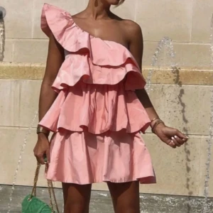 Rosa offshoulder klänning med volanger - Säljer en superfin rosa klänning med volanger från ZARA i storlek XS. Säljer den vidare då den tyvärr var för liten för mig 