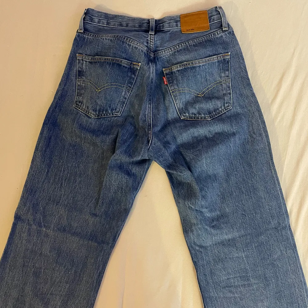 Säljer ett par klassiska Levi's 501 jeans i blå denim. De är i storlek W26 L30 och har en knappgylf. Jeansen är i bra skick och har den ikoniska Levi's-lappen på baksidan. Perfekta för en avslappnad och stilren look!. Jeans & Byxor.