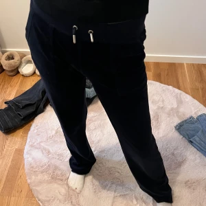 Svarta mjukisbyxor med snörning - Säljer ett par svarta mjukisbyxor i storlek dam xxs. Byxorna är superbekväma och har en snörning i midjan för justerbar passform. Perfekta för en avslappnad dag hemma eller en snabb tur till affären. Materialet är mjukt och skönt, vilket gör dem till ett måste i garderoben!