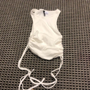 Vit ribbat linne med scrunch - Vit kort ribbat linne med scrunch i sidorna! Ny skick, aldrig använd!💕💕