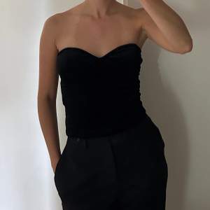 Tubtopp i sammet från NAKD i strl 36. Toppen har bh-inlägg och synliga dekorativa sömmar för en bustier look.   Fint och felfritt skick, inte använt speciellt många gånger. 