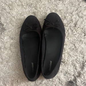 Svarta ballerinaskor från Graceland - Säljer ett par svarta ballerinaskor från Graceland. De är i syntetmaterial och har en söt rosett på tån!💕