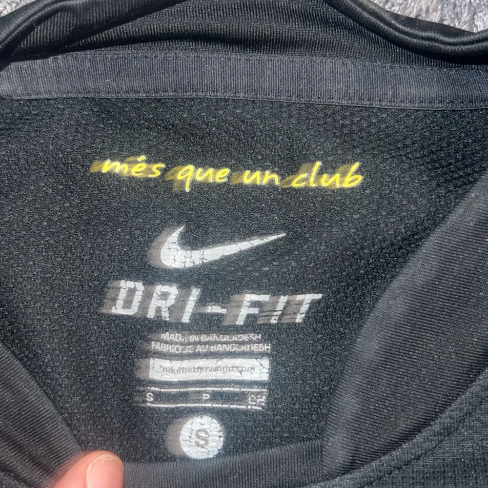 Säljer en svart långärmad FC Barcelona tröja från Nike. Tröjan har klubbens emblem på bröstet och Qatar Foundation som sponsor tryckt i gult på framsidan. Den är i Dri-Fit material och har LFP-märket på ärmen. Perfekt för alla Barca-fans! 💛Kunden står för frakten (pris kan diskuteras). T-shirts.