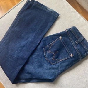 Wrangler jeans - Snygga jeans från Wrangler. Lågmidjade med mönster på fickorna. Som nya förutom att jag råkat trampa på tyget vid benet då de är lite för långa på mig (syns på bild 1) 