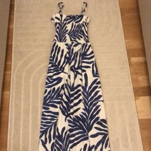 Vit och blå långklänning från H&M - KAN SÄNKA PRISET! Säljer en superfin vit och blå långklänning från H&M. Klänningen har ett snyggt bladmönster och är perfekt för sommaren. Den har smala axelband och är tillverkad i ett mjukt och bekvämt material. Perfekt för både vardag och fest! 🌿💙