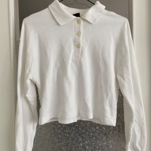 Vit croppad pikétröja - Säljer en snygg vit croppad pikétröja. Den har långa ärmar och tre knappar framtill. Perfekt för en avslappnad men ändå stilren look. Passar bra till både jeans och kjol. Köp direkt eller ge prisförslag 💛