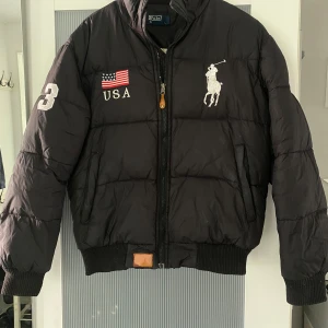 Dunjacka - En kort dunjacka från Polo Sport, varm och skön.  Innerficka och fickor med dragkedjor. 