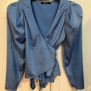 Blus - Blå satin blus. Är i storlek XS. Är i nyskick. Från ginatricot är däremot slutsåld.