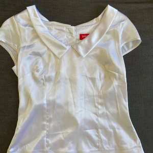 Vintage blouse - Vintage blouse i material som påminner om satin. Storlek 38/36 Man kan ha den åt båda hållen