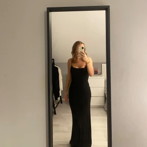 Svart långklänning från Gina Tricot - Säljer en elegant svart långklänning från Gina Tricot. Klänningen är ärmlös med smala axelband och har en tight passform som framhäver figuren. Perfekt för festliga tillfällen eller en utekväll. 