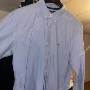 Blå Ralph lauren skjorta  - En blå skjorta i bra skick från Ralph Lauren i slim fit pass form. 