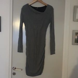 Grå långärmad klänning från H&M - Säljer en stilren grå klänning från H&M. Den är långärmad och har en tight passform som framhäver figuren. Perfekt för både vardag och fest!