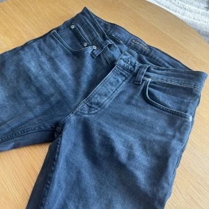 Nudie jeans - Säljer ett par snygga mörk grå nudie jeans i modellen Grim Tim. Använda ungefär 10 gånger, och har inga defekter. Pris kan diskuteras vid snabb affär!
