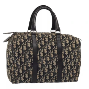 Christian Dior Boston väska - Ursprung: Frankrike          Material: travduk Färg: marinblå och beige   Tillbehör: inga   Exteriör: Bra, med några tecken på användning. Insida: Bra, med några tecken på användning. B 30cm x B 18cm D 15cm