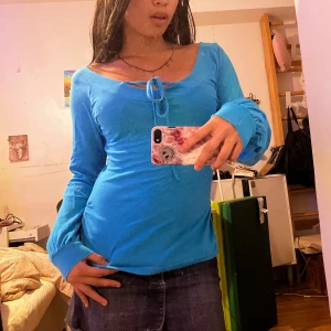 Blå långärmad topp med knyt - Säljer en snygg blå långärmad topp med knyt framtill.Toppen har en tight passform och är perfekt för både vardag och fest. Den är gjord i ett mjukt och bekvämt material o är lite ”puffig” i ärmarna! Köpte för 199kr använt 1-2 gånger‼️använd ej köp nu‼️