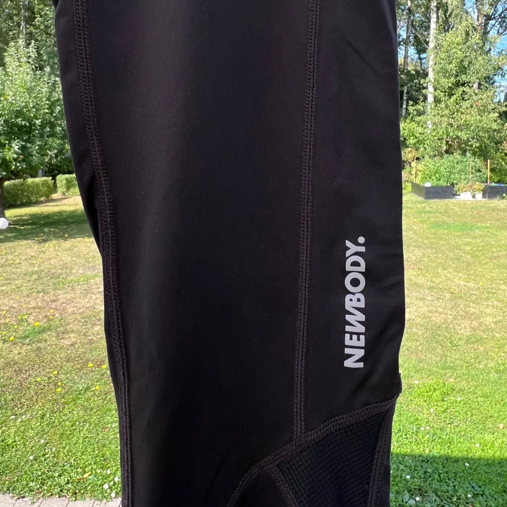 Ett par svarta träningstights från Newbody. Detalj på baksidan som gör att de andas bra. Storlek M och sparsamt använda 🩷🌷  Innerbenslängd: 67 cm Midja: 76 cm. Sportswear.