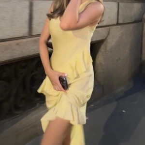 Gul klänning med volangdetaljer - Säljer en superfin gul klänning med volangdetaljer. Den har en v-ringad hals och är perfekt för sommarens fester. Klänningen har en normal passform (figursydd) och är gjord i ett lätt och bekvämt material. Aldrig använd av mig, skriv för egna bilder❤️