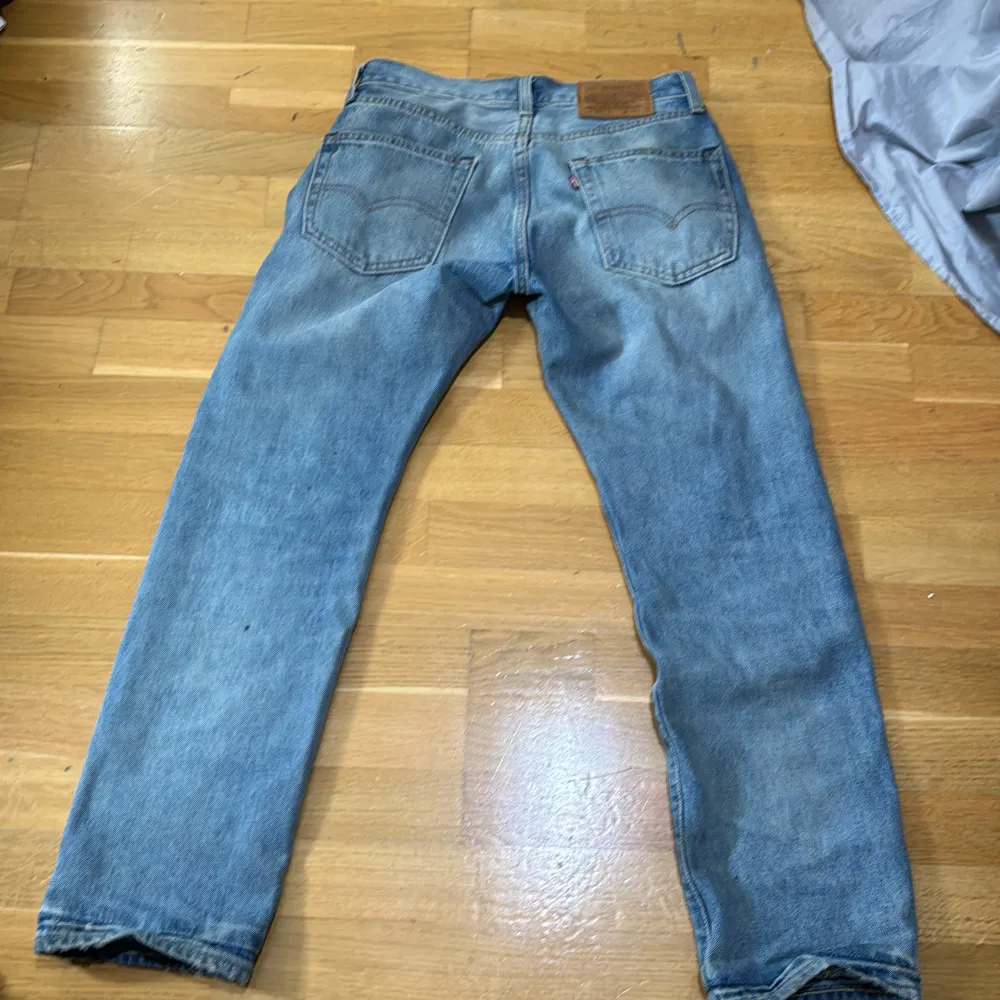 Säljer ett par klassiska Levi's Premium jeans i en snygg blå tvätt. De har en straight passform och är i välanvänt skick, vilket ger dem en cool vintage-look. Perfekta för en avslappnad stil. Model 551. Jeans & Byxor.