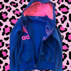 Adidas hoodie - En blå/rosa adidas hoodie, god skick, köpt på plick och taggen var redan klippt från första början, ”knapparna” vid hoodien är tyvärr sönder men annars passar den bra!🍂💞
