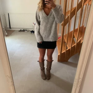 Grå tjocktröja i alpacka och ull - Grå v-ringad tjocktröja från Selected Femme i superbra skick. Tröjan är en blandning av alpacka, ull och polyester. Perfekt i höst och vinter!! Har endast använts några få gånger och har tagit väl hand om den. Är i storlek L men passar perfekt för S!