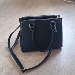 Fin vardagsväska - Smidig och rymlig väska med flera fack. Har tyvärr inte kommit till användning då den inte riktigt är min stil. Ca 30x20x20cm stor.