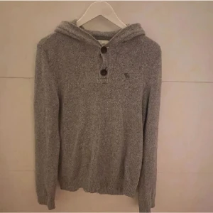 Stickad hoodie  - Skitsnygg stickad hoodie från abercrombie och fitch, den är i bra skick men har ett litet hål på armen men inte så synligt 