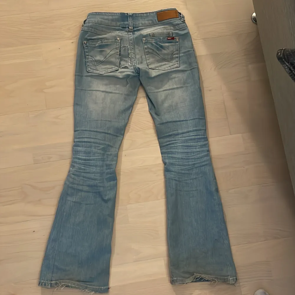 Säljer ett par ljusblå bootcut jeans i bra skick. De är lågmidjade och har en slitning på baksidan men som jag har fixat och som man inte tänker. Skriv om ni har några frågor💗 innerbenslängden är 80cm och midjemåttet mätt rätt över är 37cm. Jeans & Byxor.