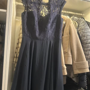 Mörkblå spetsklänning från Esprit small - Säljer en elegant mörkblå klänning från Esprit. Den har en vacker spetsdetalj upptill och en flytande kjol. Perfekt för festliga tillfällen! Klänningen har en dragkedja i sidan för enkel påklädning.