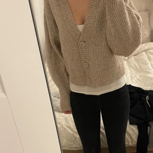 Beige stickad kofta - Beige stickad kofta från Gina tricot. Den är i bra skick men lite noppig men inget man tänker på när man har på sig den.