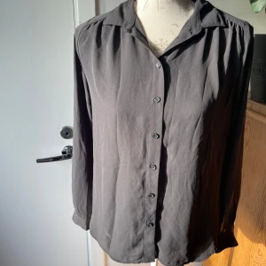 Blus  - Svart blus från H&M i stl 34. 100% polyester.