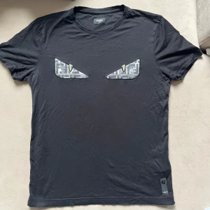 Fendi T Shirt - Snygg och fräsch Fendi t shirt i storlek S. Är i väldigt bra skick. Använd fåtal gånger. Är för liten på mig så den ligger bara i garderoben just nu. Beställd från Farfetch. Kvitto finns. 