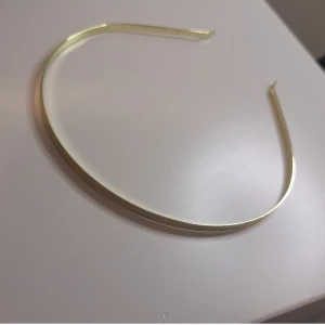 Guldigt diadem - Snyggt och enkelt guldigt diadem som passar perfekt för att ge en touch av elegans till vilken outfit som helst. Det är smalt och stilrent, vilket gör det lätt att matcha med olika stilar. Perfekt för både vardag och fest!