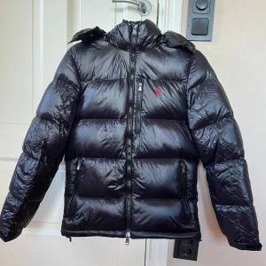 POLO RALPH LAUREN - THE GORHAM GLOSSED DOWN JACKET - Säljer denna helt nya och oanvända polo jacka då den inte satt bra mig. Den är svart i storlek xs och kostar 6095 ny. 