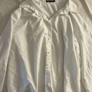 Skjorta - Vit skjorta med långa ärmar och knappar framtill. Skjortan har en klassisk krage och är tillverkad i ett lätt och bekvämt material. Säljs för 50
