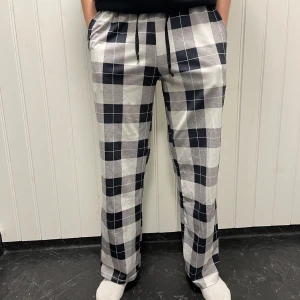 Rutig byxa med snörning - Säljer ett par superbekväma byxor med svart och vit rutigt mönster. De har en avslappnad passform och snörning i midjan för extra komfort. Perfekta för en chill dag hemma eller en avslappnad utflykt. 🖤🤍