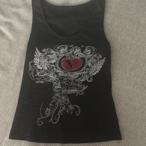 Svart linne med rhinestones💕 - Ett jättesnyggt typ y2k/drainer linne med vitt tryck och röda rhinestones💕