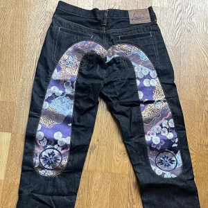 Unika jeans med blommigt mönster - Säljer ett par riktigt coola jeans med ett unikt blommigt mönster på baksidan. Supersnygga och sitter ”baggy”.