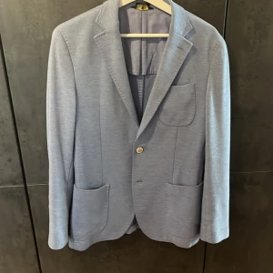 Massimo Dutti kavaj - Snyggaste kavajen jag ägt. Riktigt fräsch ljusblå kavaj med bruna detaljer i mocka från Massimo Dutti.  Säljer den då jag tyvärr har tröttnat  en del på den.  Skick: 8/10