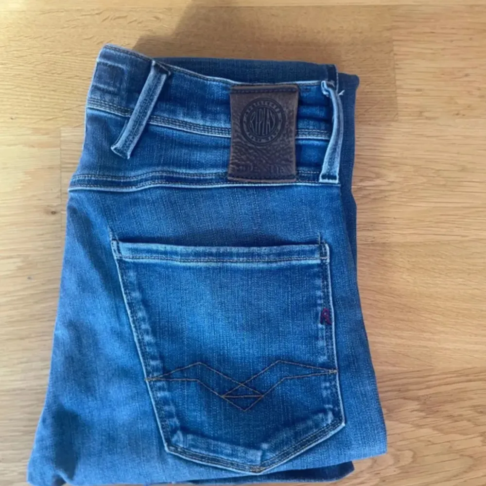 Säljer ett par snygga blå jeansbyxor i klassisk stil. De har en normal passform och är tillverkade i slitstarkt denim. Byxorna har en knappgylf och fem fickor, vilket ger dem en tidlös look. Perfekta för både vardag och fest!. Jeans & Byxor.