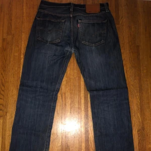 Mörk blå levis jeans - Jeansen har några små sluttningar som knappt syns och ett litet hål som går att sy ihop enkelt