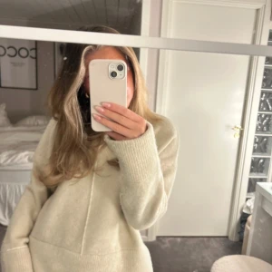 Beige stickad tröja från Zara - Mysig beige stickad tröja från Zara med ribbade muddar och rund hals. Perfekt för kyliga dagar och enkel att matcha med olika outfits. Tröjan har en stilren design med diskreta sömmar framtill.