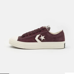 Vinröda sneakers från Converse - Snygga vinröda sneakers från Converse i mocka med klassisk stjärndetalj på sidan. Köpare står för frakt eller mötas på Östermalm. Har haft i ungefär 6 månader, de är bra kvalitet.  Skriv ifall du har frågor❤️