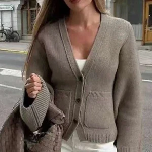 Beige stickad kofta - Säljer en stilren beige stickad kofta med v-ringning och knappar framtill. Koftan har långa ärmar och praktiska fickor. Kan skicka egen bild privat🫶🏻