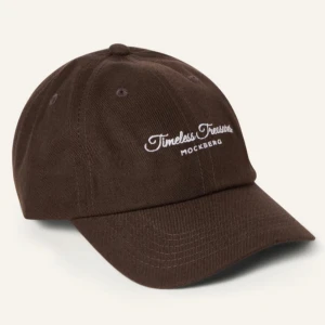  Keps från Mockberg - Snygg brun keps från Mockberg med broderad text 'Timeless Treasures' framtill. Kepsen har en justerbar rem baktill för perfekt passform. HELT NY MED PRISLAPP‼️