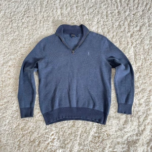 Ralph Lauren Zip-Tröja - Hej! Jag säljer en stilren och klassisk Ralph Lauren zip-tröja i storlek M. Tröjan är i fantastiskt skick, sparsamt använd och utan några defekter. Perfekt för både vardag och lite mer uppklädda tillfällen! Har ni några frågor är det bara att höra av er!