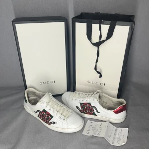 Gucci Ace Snake - Äkta gucci ace med kvitto!! Har lite skador, lädret har spruckit vid en söm och är slitna inuti, men skulle säga att skicket är 7/10. Riktigt snygga skor som passar till alla outfits. Skriv för fler bilder eller vid funderingar 🙌😁