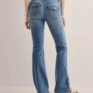 Bootcut midwaist jeans - Snygga blå bootcut jeans från ONLY med medelhög midja och snygga bakfickor med knappdetaljer. Super sköna. Storlek L/32. Använda fåtal gånger, köpta för 1 månad sen. Nypris 599kr. Säljer för 480kr + frakt eller lägg ett prisförslag🩷🙌🏼
